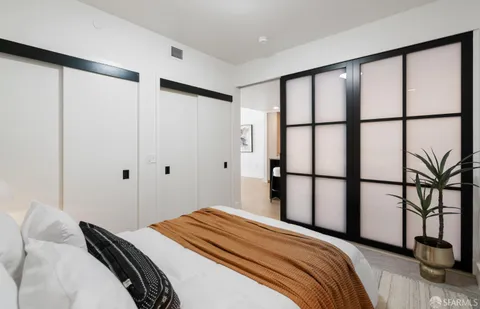 a bedroom with a bed and painting on the wall