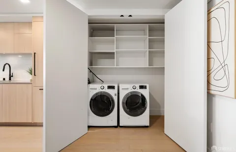 a living room with furniture stairs and a large window