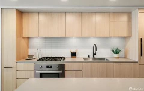 a kitchen with stainless steel appliances granite countertop a stove a sink and a white cabinets