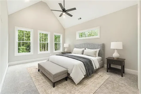 a spacious bedroom with a bed a couch and windows