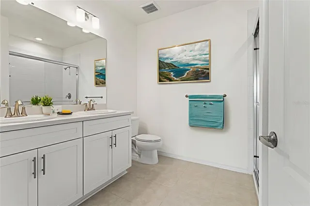 a bathroom with a toilet a sink a mirror and a shower