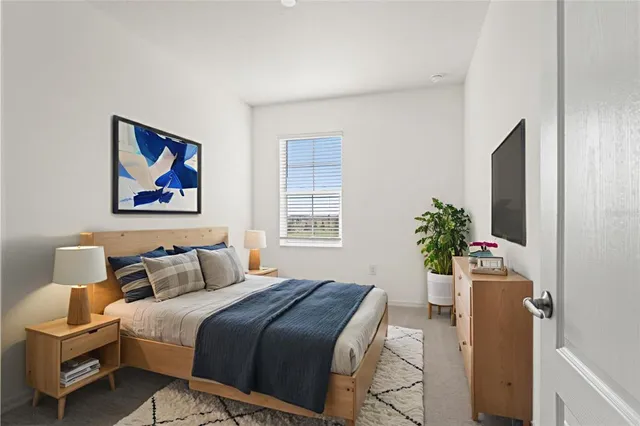 a bedroom with a bed and a potted plant