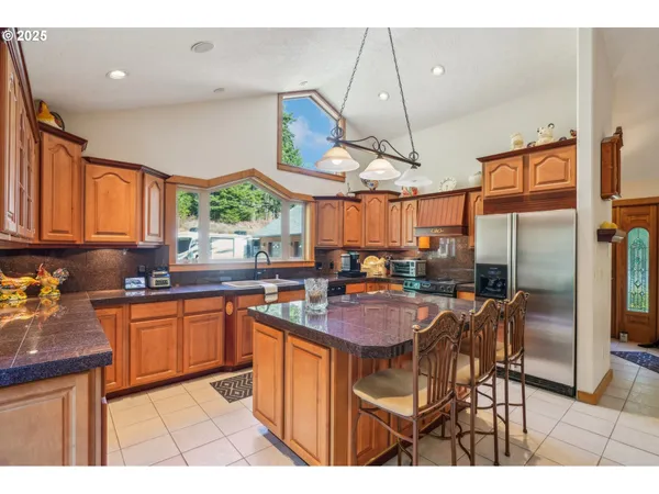 a kitchen with stainless steel appliances granite countertop a sink a stove and a wooden floors