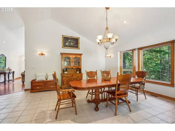 a dining room with furniture a large window and a chandelier