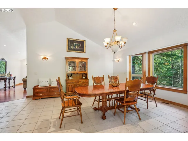 a dining room with furniture a large window and a chandelier