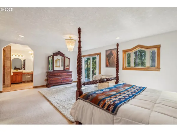 a bedroom with a large bed and a chandelier