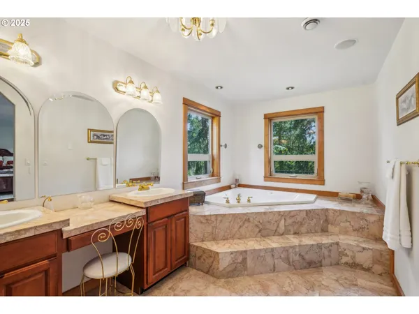 a spacious bathroom with a tub sink and mirror