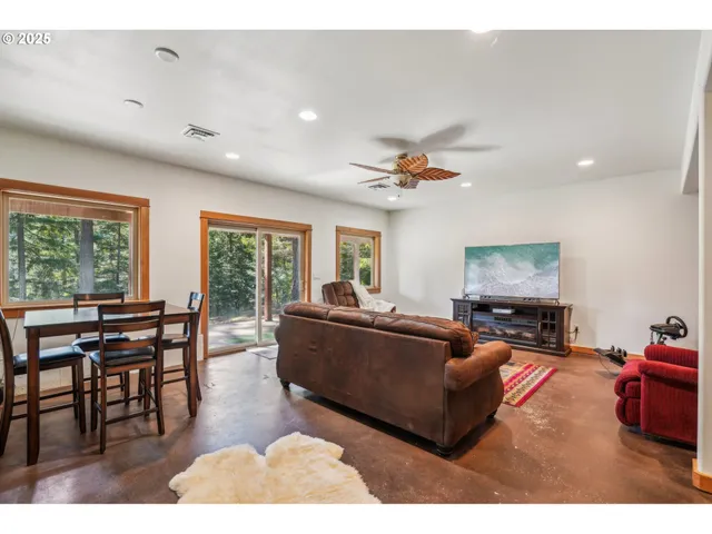 a living room with furniture a flat screen tv and a large window