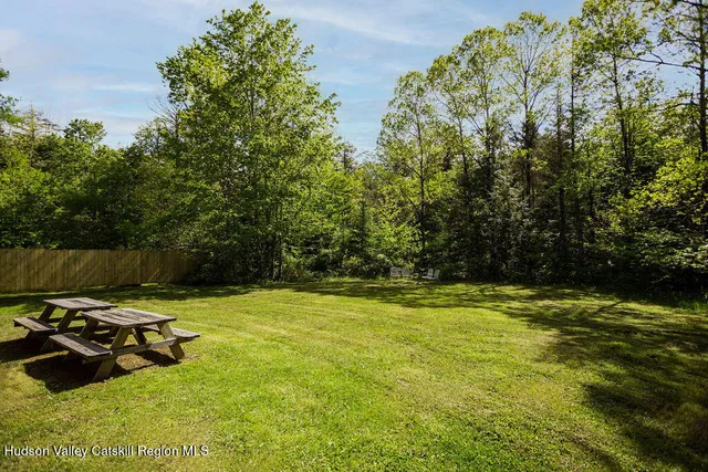 a view of a swimming pool with lawn chairs and plants