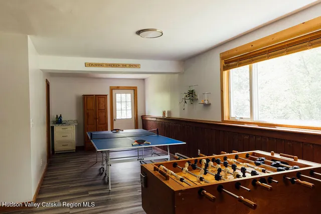 a living room with stainless steel appliances furniture a rug and a window