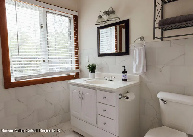 a bathroom with a sink toilet and window