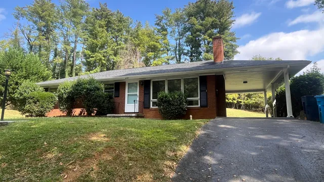 a view of a house with a yard and sitting area