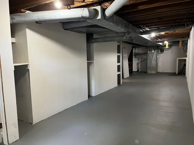 an empty room with wooden floor and a bathroom