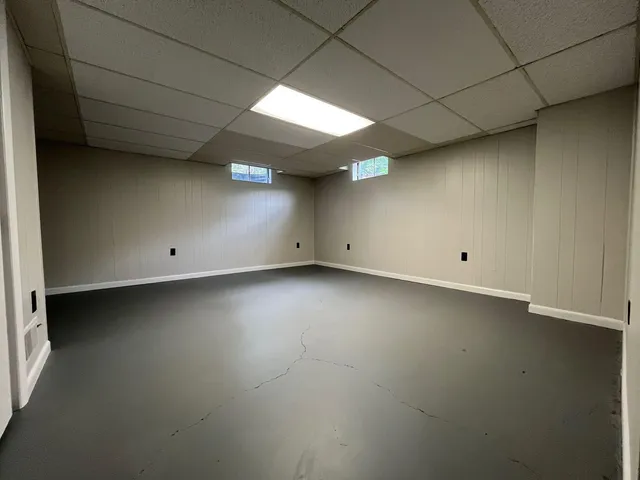 an empty room with a ceiling fan and window