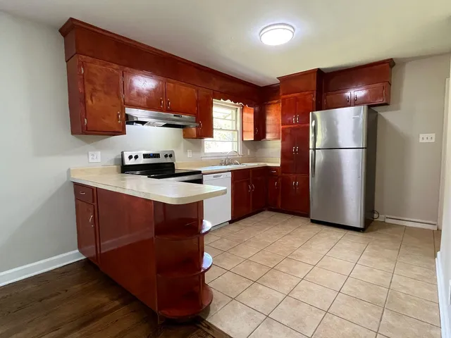 a kitchen with stainless steel appliances granite countertop a stove a refrigerator and a sink