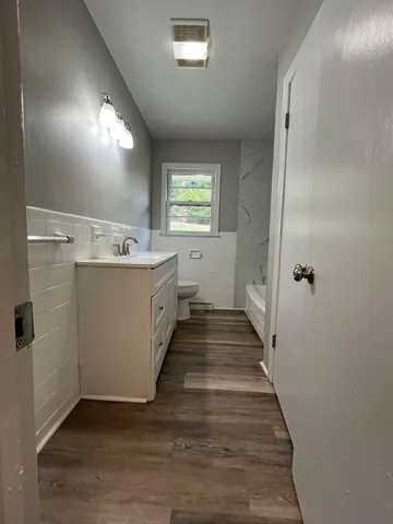 a view of a hallway with wooden floor and staircase