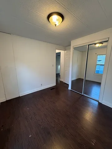an empty room with wooden floor and door