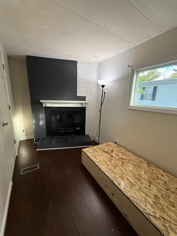 a living room with hard wood floors and a fireplace