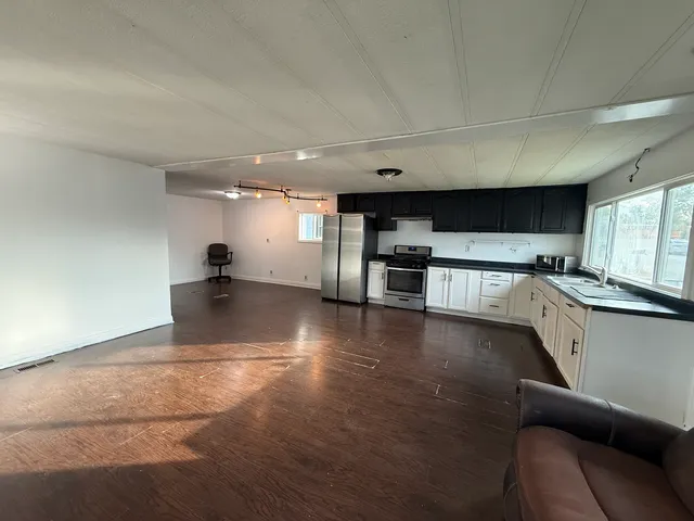 a view of kitchen with stainless steel appliances refrigerator stove microwave and cabinets