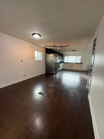 an empty room with staircase and windows