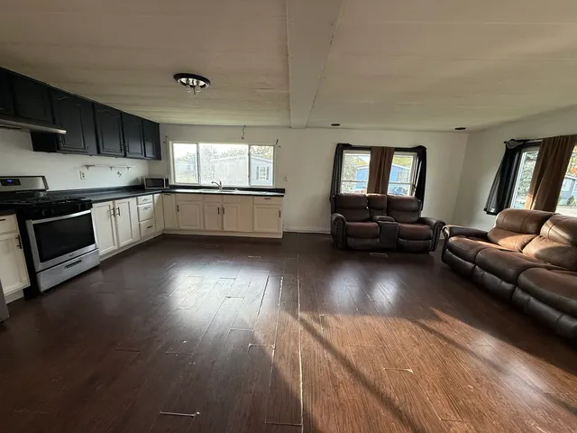a view of a kitchen with a sink wooden floor and a window