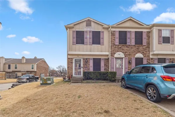 a view of a car parked in front of a brick house