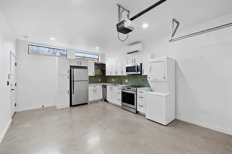 a kitchen with stainless steel appliances a refrigerator and white cabinets