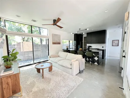a living room with furniture a flat screen tv and a large window