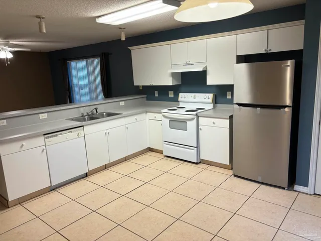 a kitchen with cabinets and white stainless steel appliances
