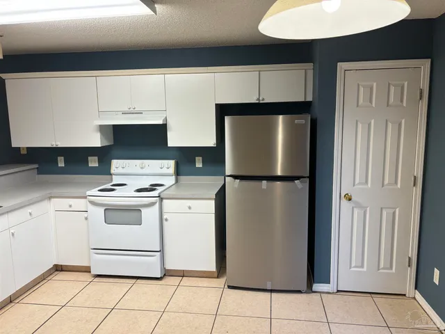 a kitchen with a stove top oven and cabinets