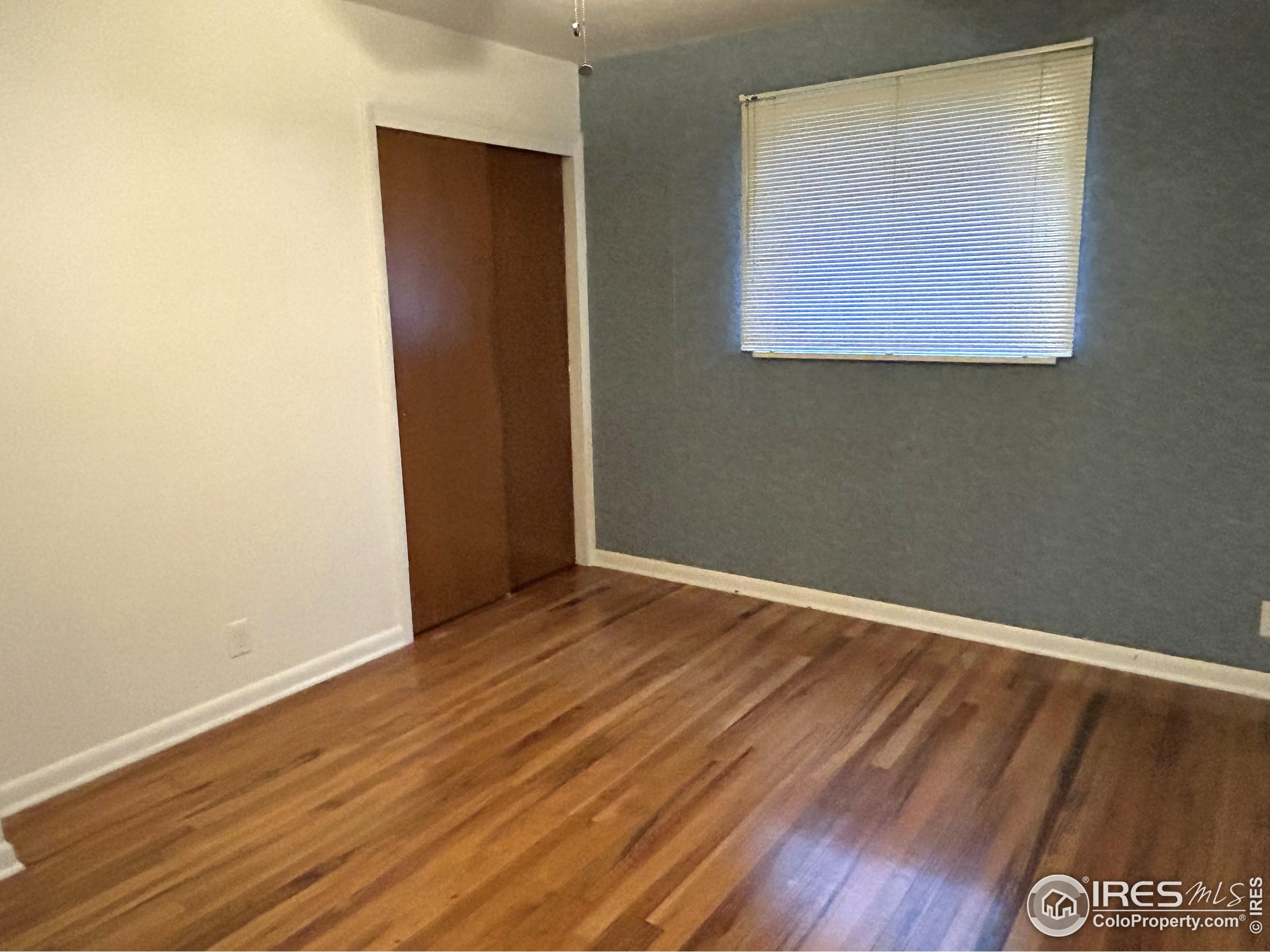 123 Balsam Street Fort Morgan, CO 80701 - Photo 8 of 34 an empty room with wooden floor and windows