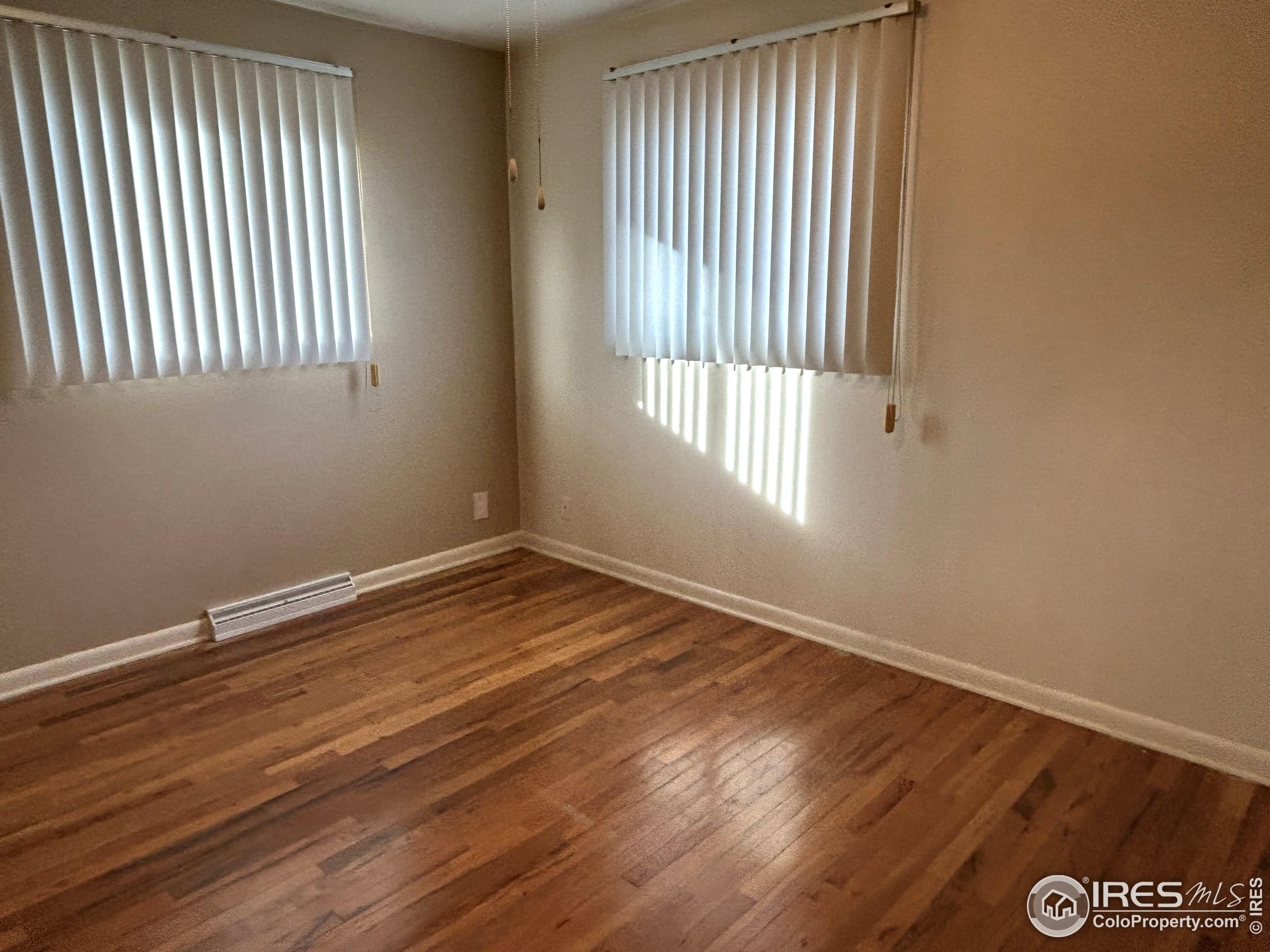123 Balsam Street Fort Morgan, CO 80701 - Photo 10 of 34 an empty room with wooden floor and windows