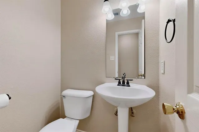 a bathroom with a sink a toilet and a mirror