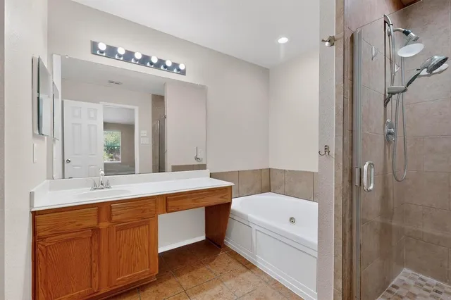 a bathroom with a tub a sink shower and mirror