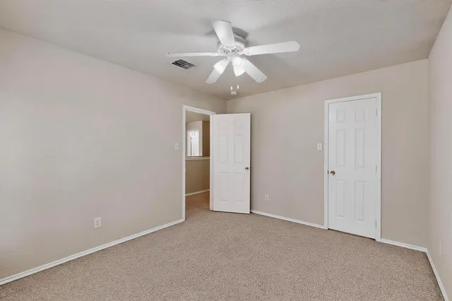 an empty room with a ceiling fan and a window