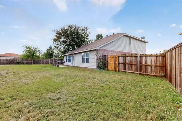a view of a backyard with plants and large trees