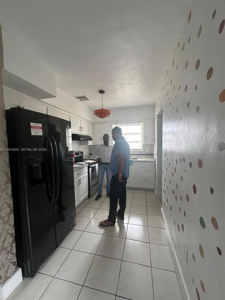 6443 Perry Street Hollywood, FL 33024 - Photo 15 of 24 a kitchen with stainless steel appliances granite countertop a refrigerator and a sink