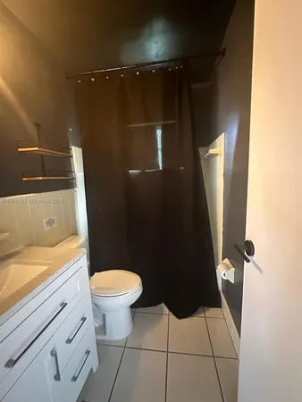 a bathroom with a granite countertop toilet sink and mirror