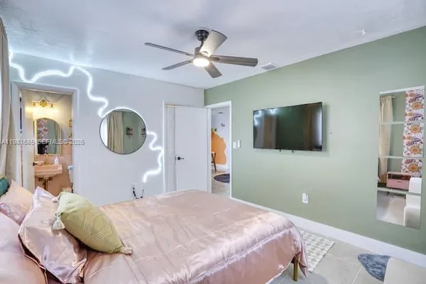 a bedroom with a bed and a mirror on the dresser