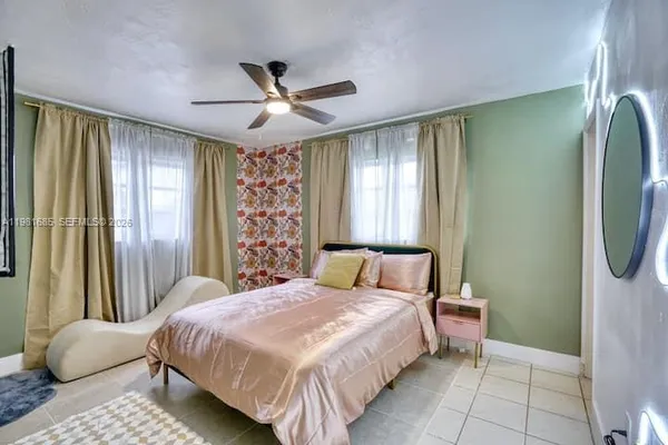a bedroom with a bed mirror and window