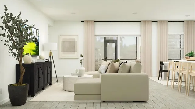 a living room with furniture a dining table and a potted plant