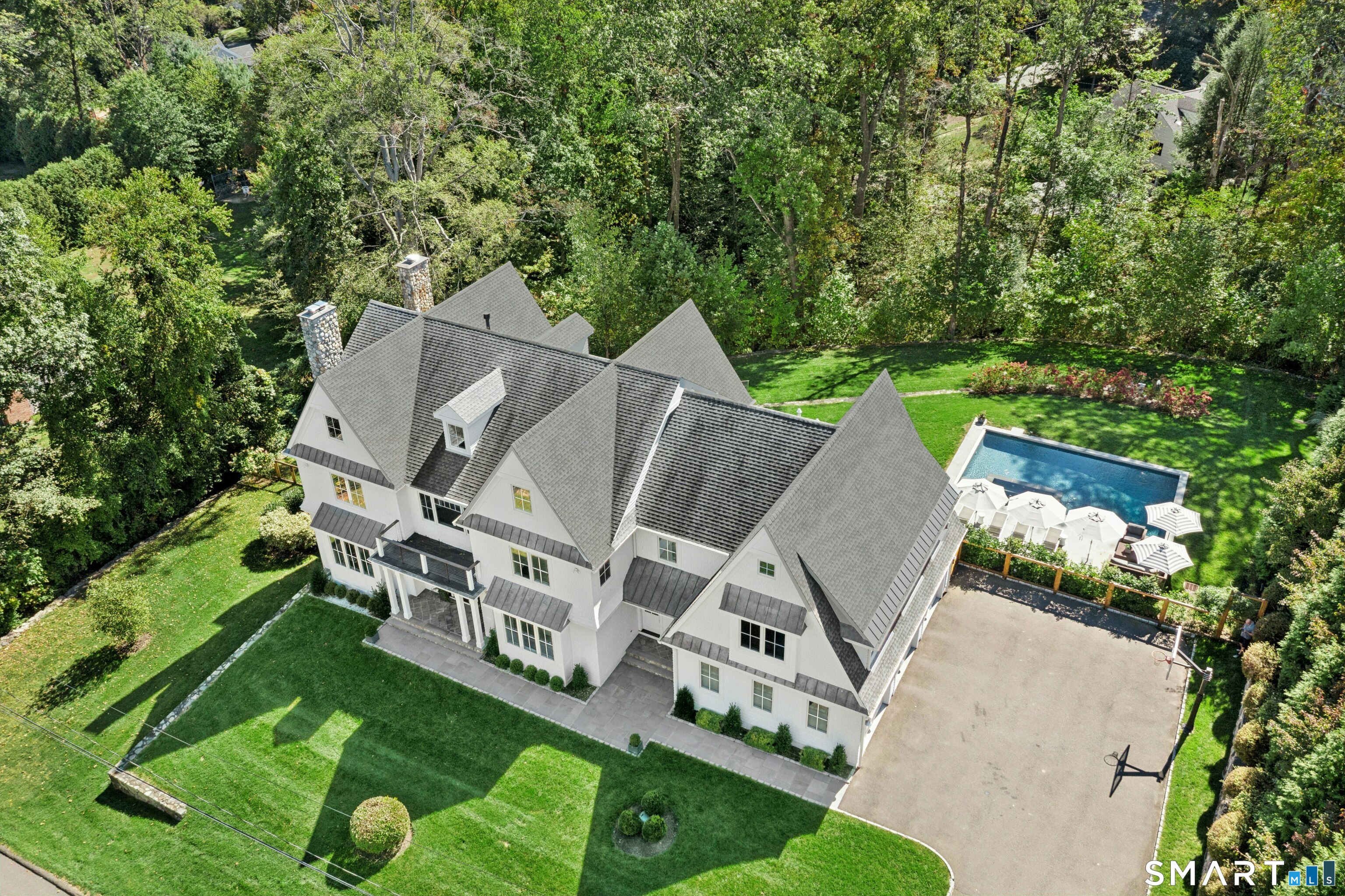 an aerial view of a house with swimming pool and garden