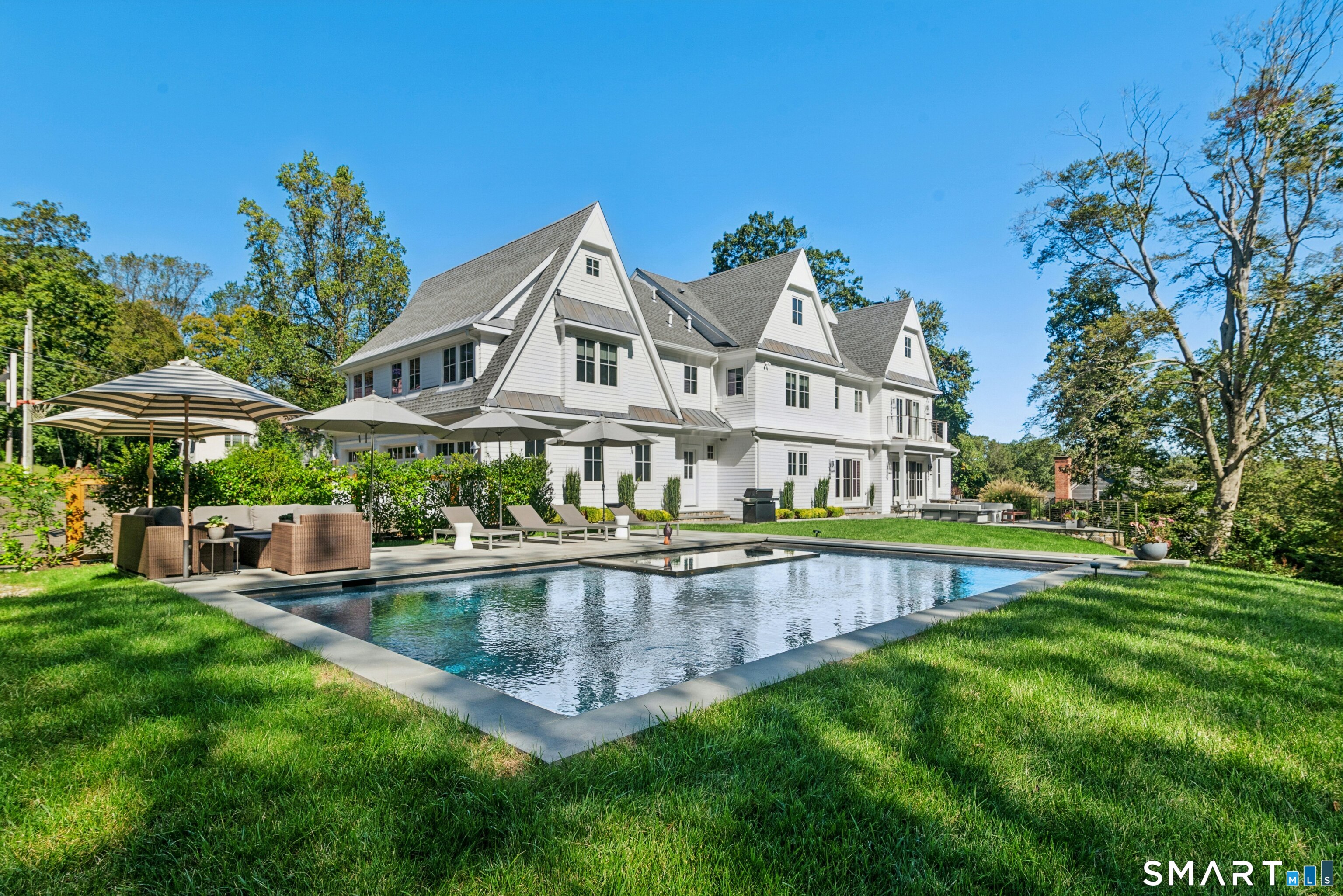 42 Hillcrest Road New Canaan, CT 06840 - Photo 36 of 38 a view of a house with a yard table and chairs