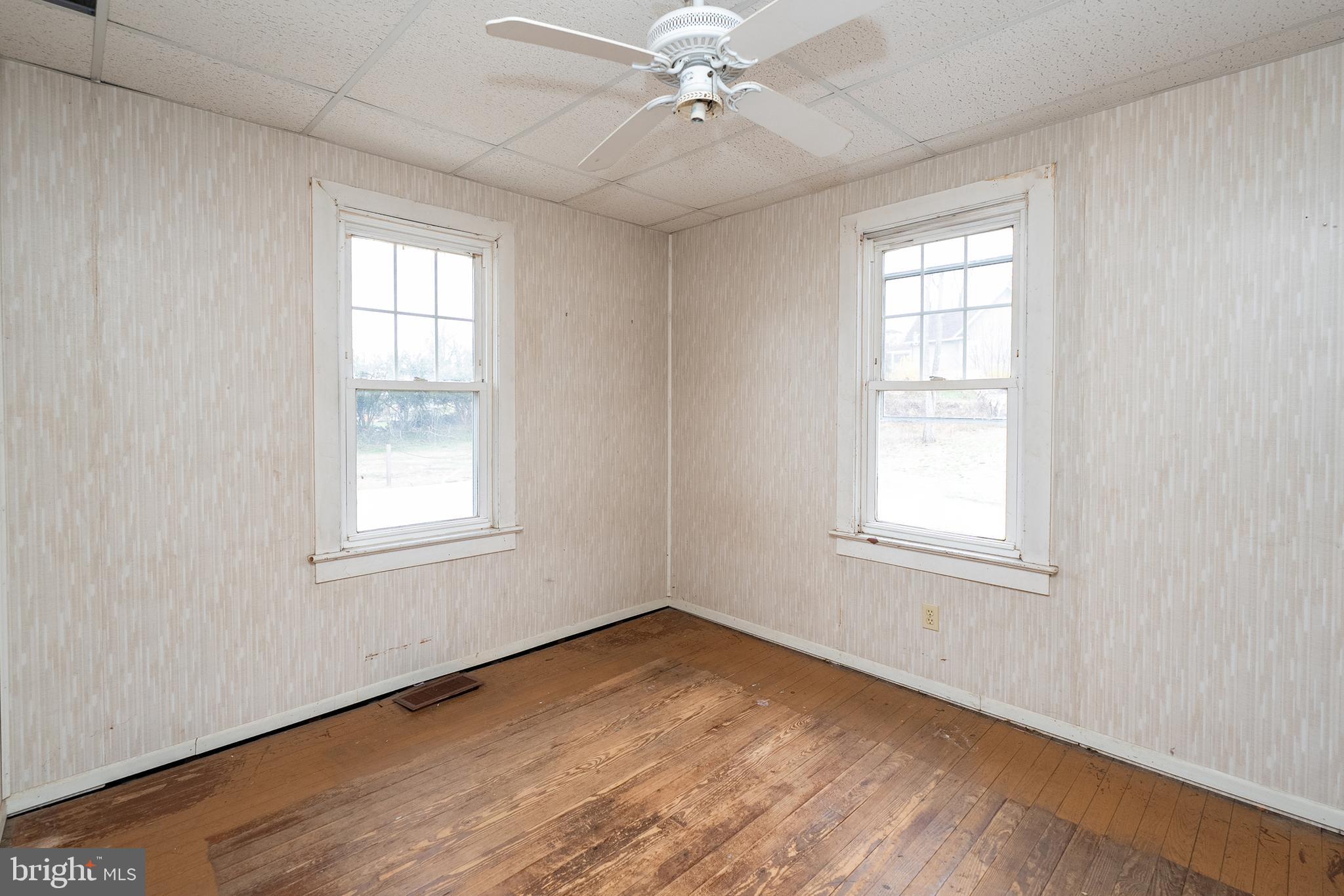 1401 Glassboro Road Wenonah, NJ 08090 - Photo 27 of 41 an empty room with wooden floor windows ceiling fan and windows