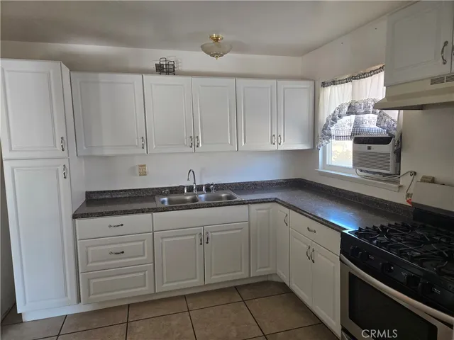 a kitchen with granite countertop white cabinets and stainless steel appliances