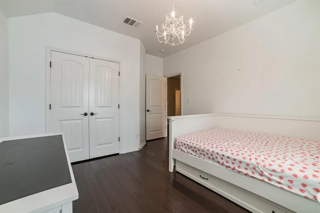 a bedroom with a large bed and a chandelier