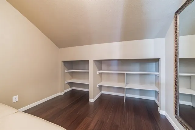 a view of an empty room with a wooden floor and a window