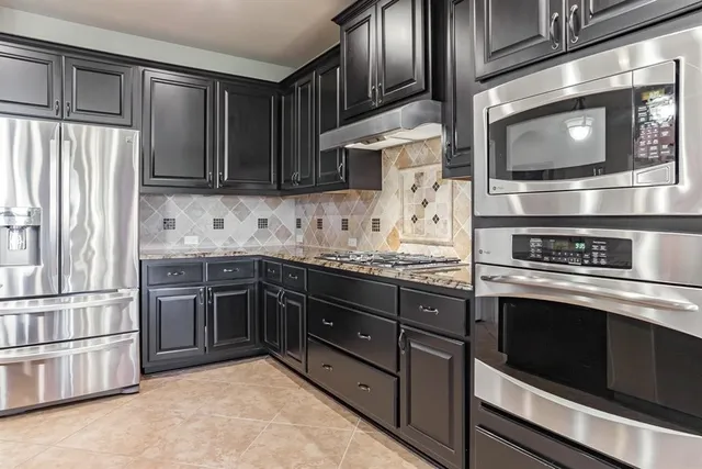 a kitchen with stainless steel appliances granite countertop a refrigerator microwave and stove