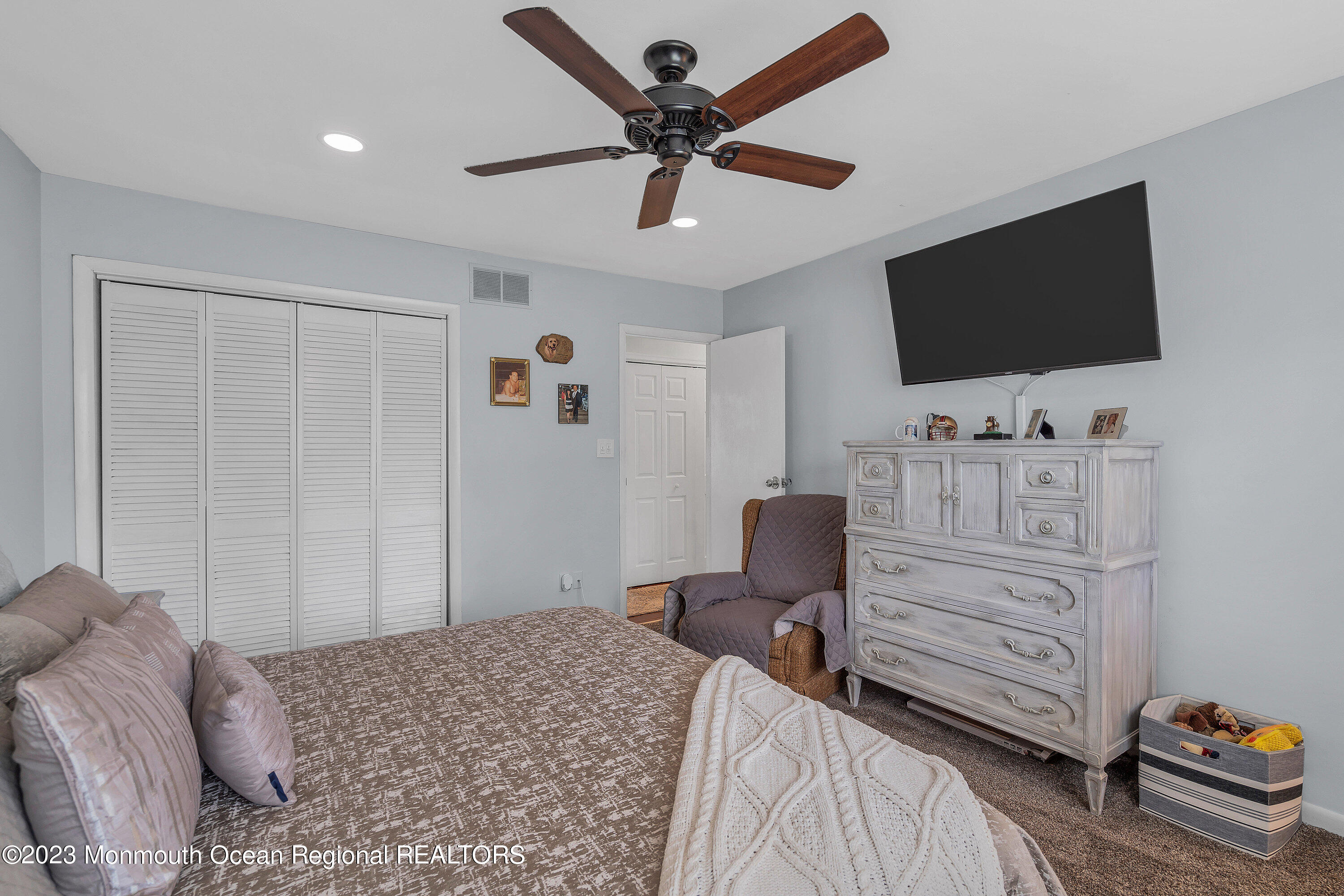 20 Woodland Road Bayville, NJ 08721 - Photo 46 of 62 a bedroom with a bed and a flat screen tv