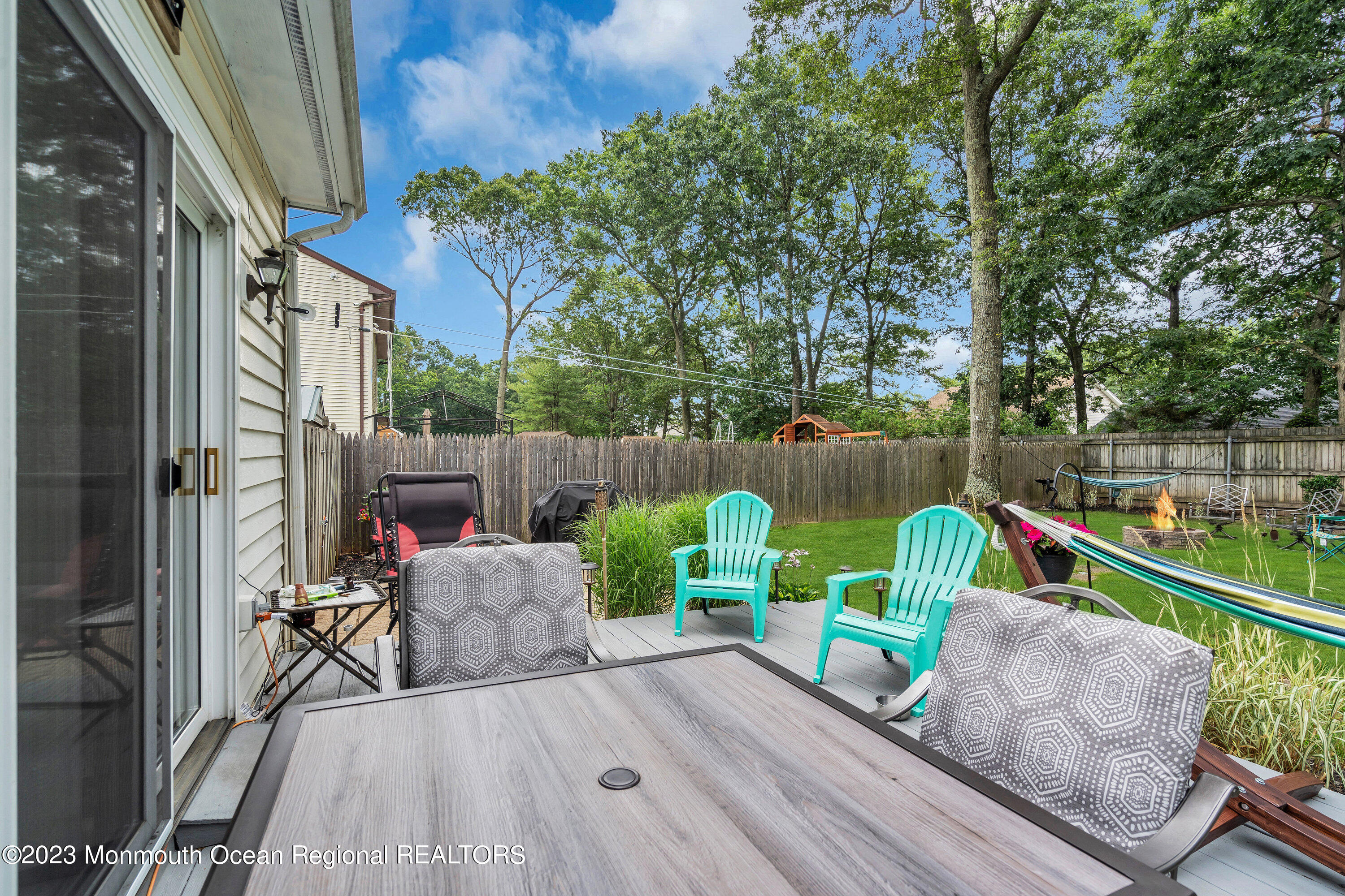 20 Woodland Road Bayville, NJ 08721 - Photo 61 of 62 a view of deck with table and chairs couches and wooden fence